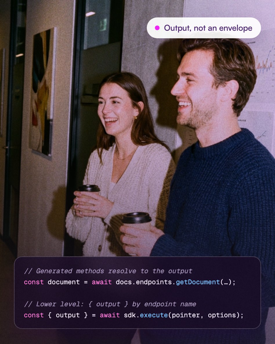 A woman and a man smiling and holding takeaway coffee cups, standing indoors near a wall with charts and artwork. Overlaid text says 'Output, not an envelope' and shows JavaScript code snippets about awaiting document endpoints and executing SDK methods to get output.