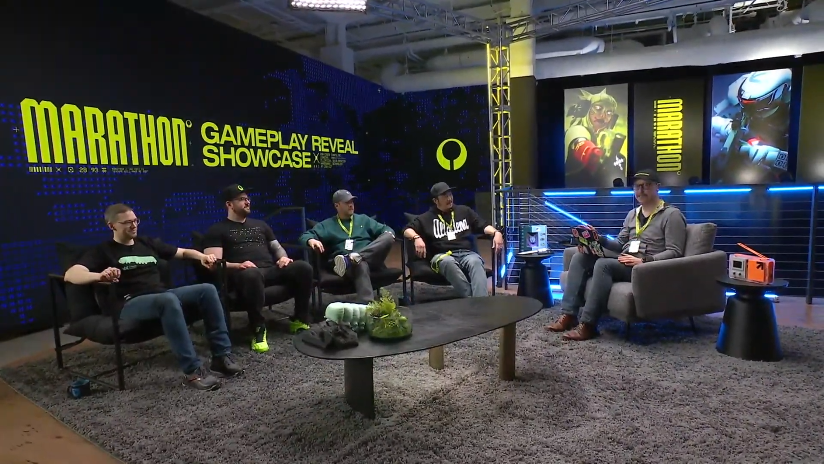 Five men seated in a studio setup with Marathon Gameplay Reveal Showcase text on a black and blue backdrop.