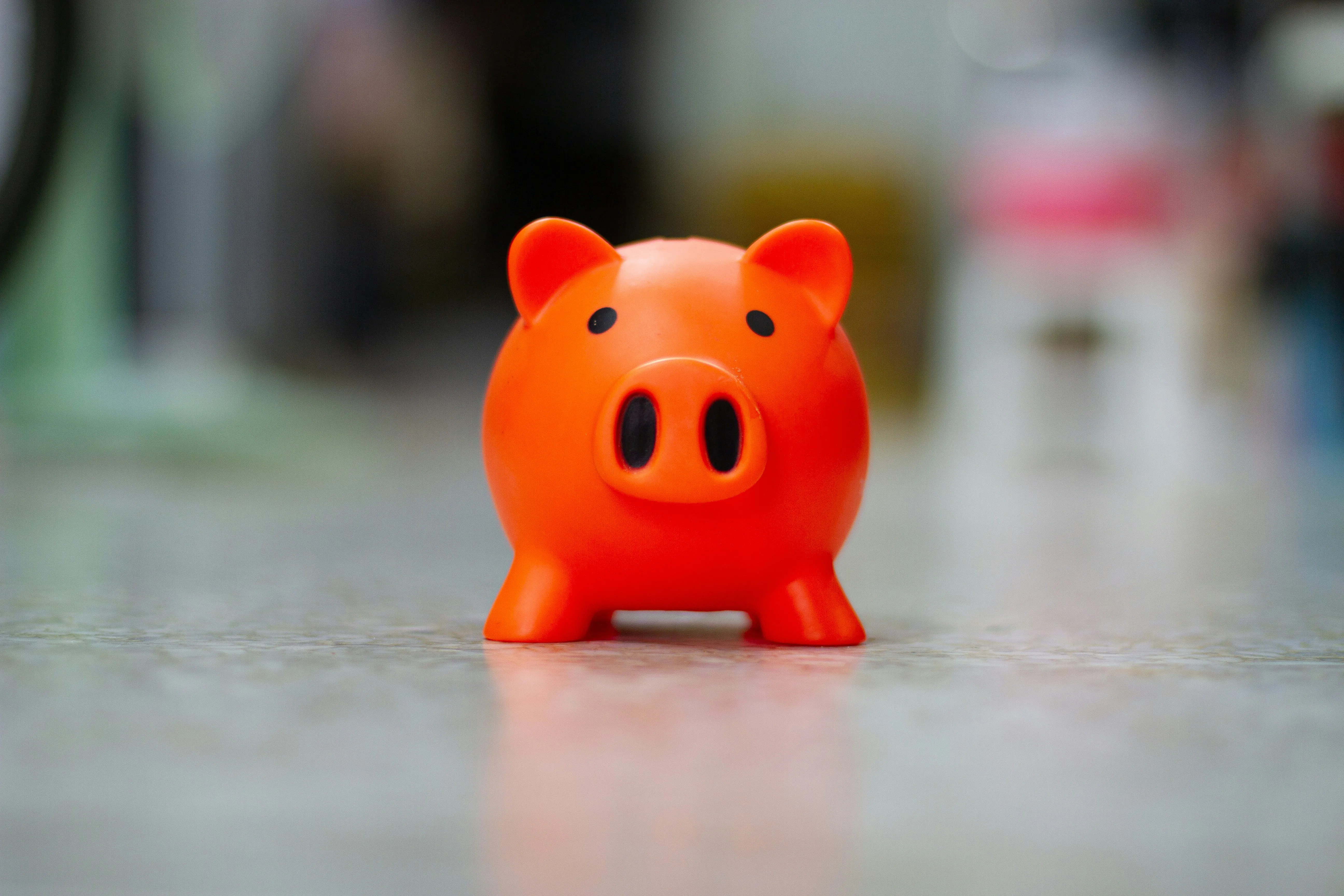 Orange piggy bank on a tiled floor
