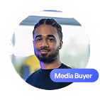 Portrait d'un homme souriant avec une étiquette 'Media Buyer'.
