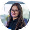 Portrait d'une femme souriante portant des lunettes et un sweat à capuche noir.