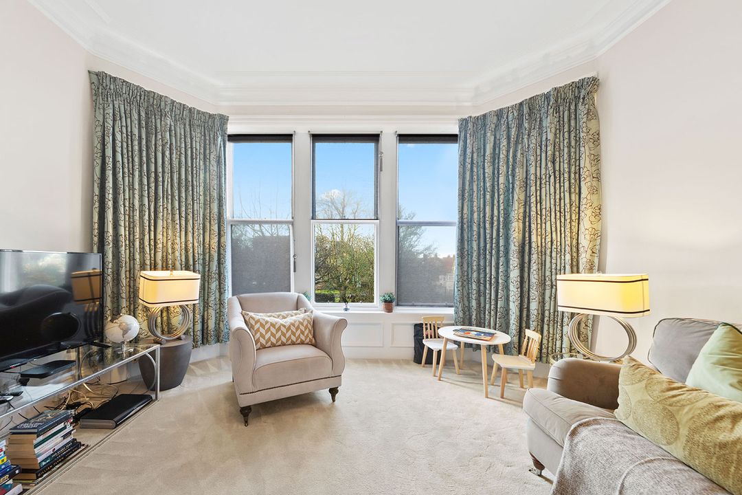 Bay-windowed living room with armchairs and soft lamps at The Royal Hall Retreat