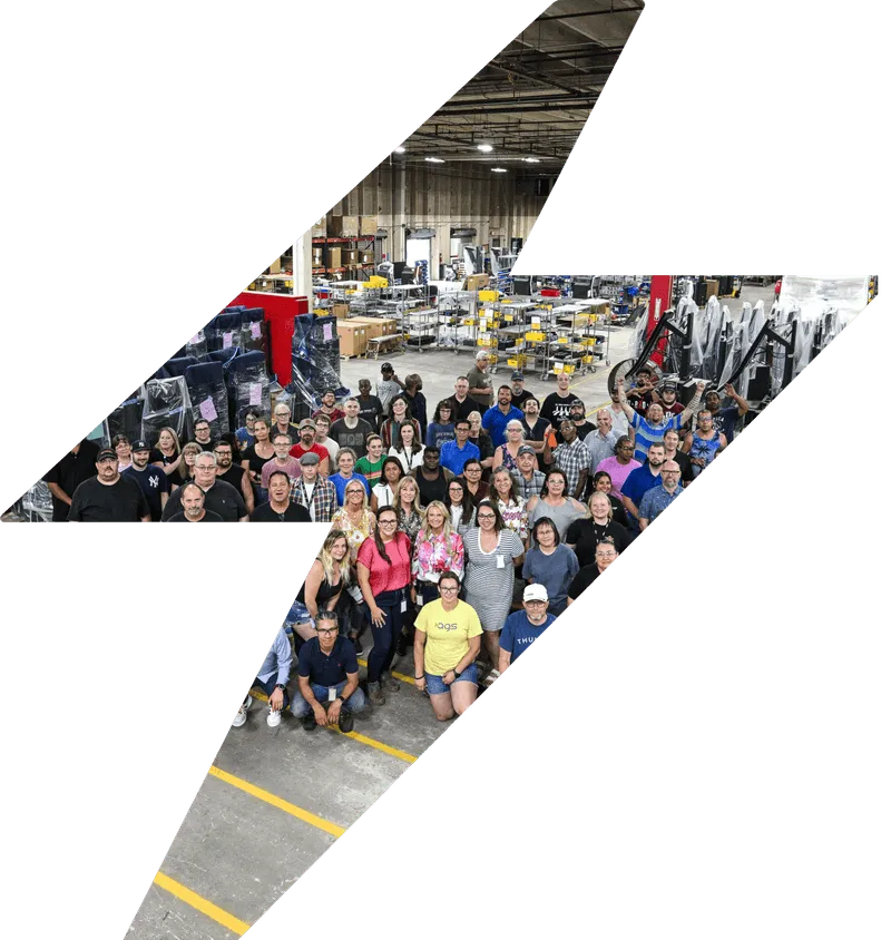 AGS team photo in manufacturing facility with diverse workforce