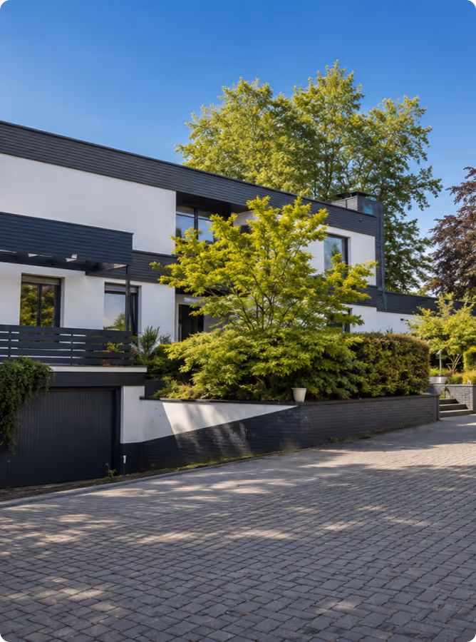 Modernes Einfamilienhaus mit weißer Fassade, Garten und Garage
