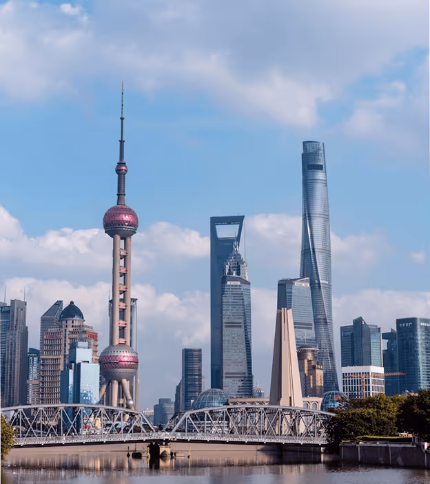 Skyline of Shanghai with Oriental Pearl Tower, Shanghai Tower, and modern skyscrapers under blue sky.