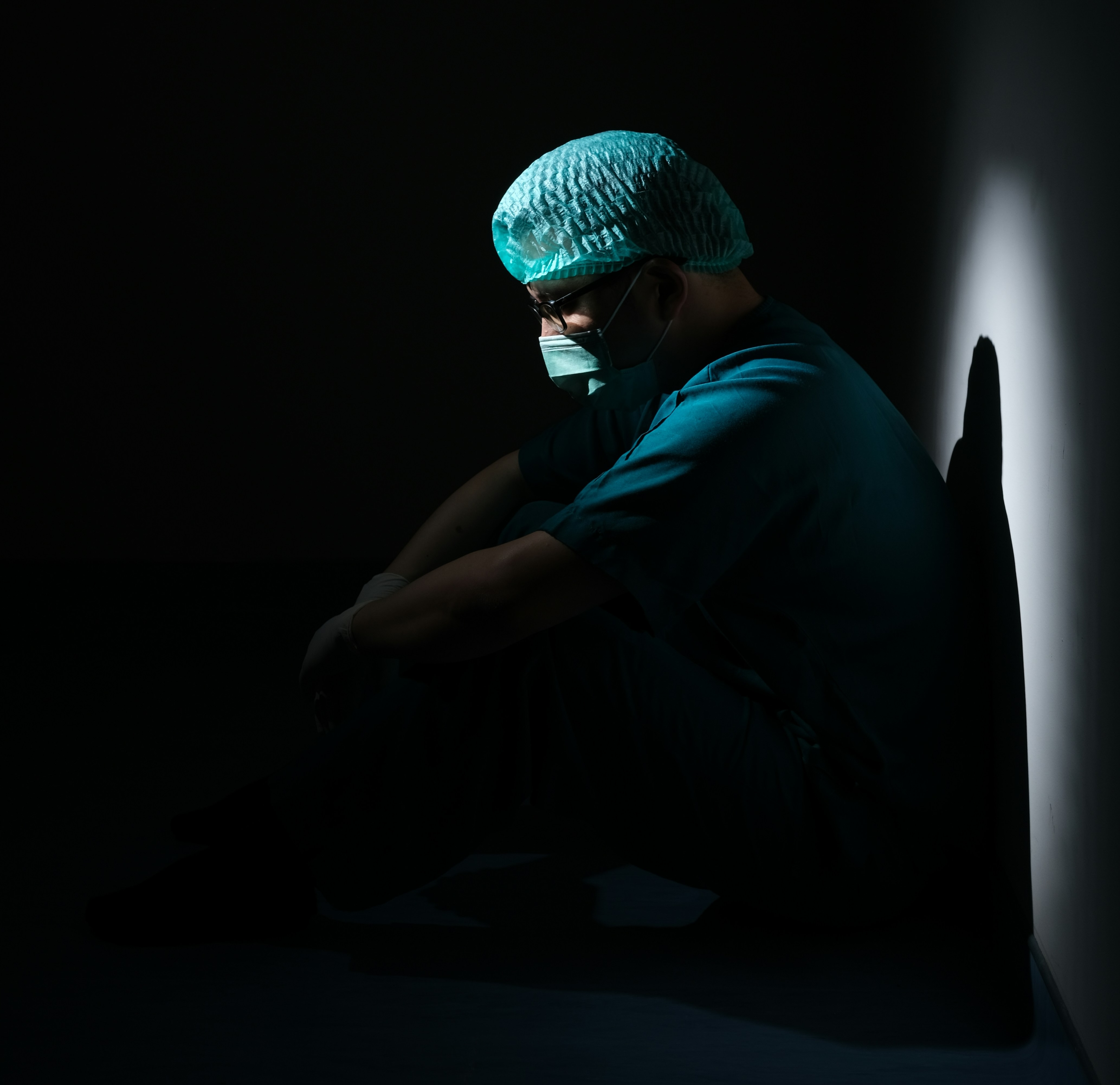Veterinarian contemplating in a dark room after an anesthetic loss.