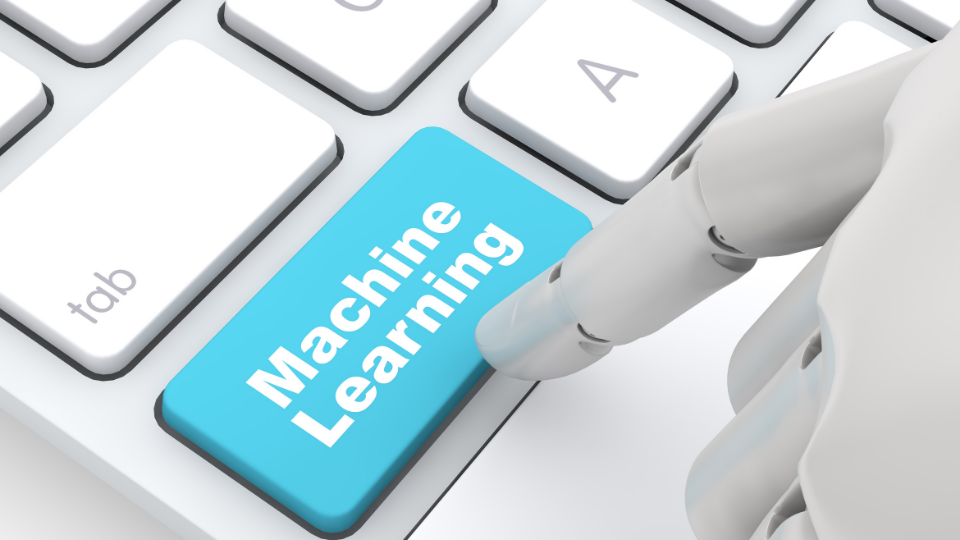 Alt text: A robot hand pressing a button that says "Machine Learning" on a keyboard