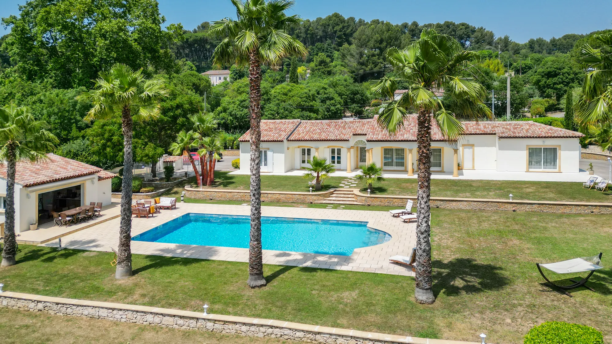Vue aérienne de la villa, de la piscine et du jardin arboré