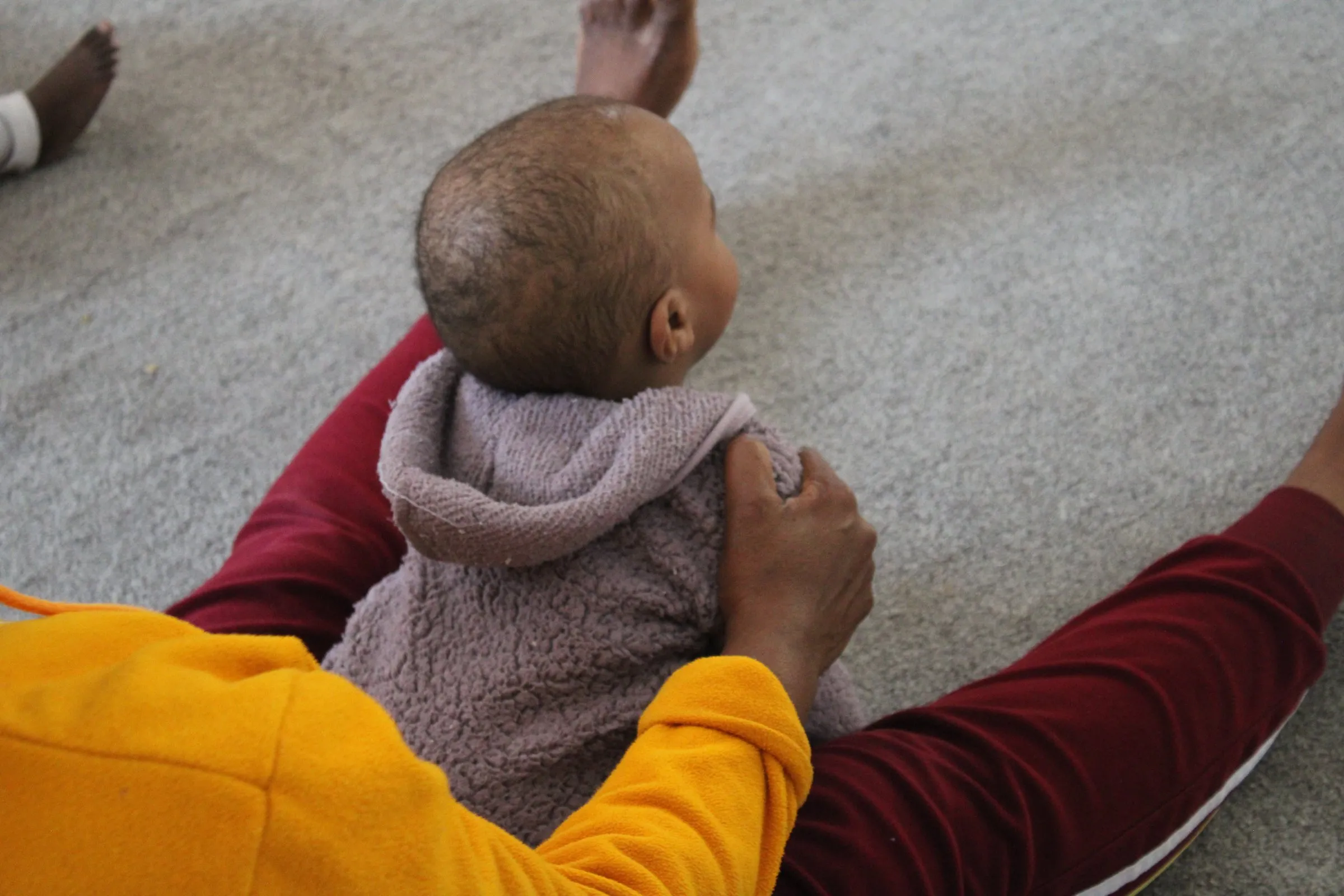 A caregiver holding a baby at Lorato House