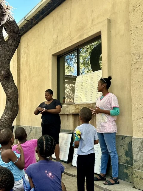 A Deaf Heart Sign Language session outdoors, with children seen from behind