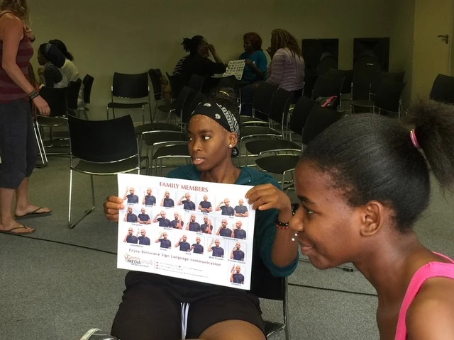 A Deaf Heart Sign Language session, with a participant holding up a family members sign chart