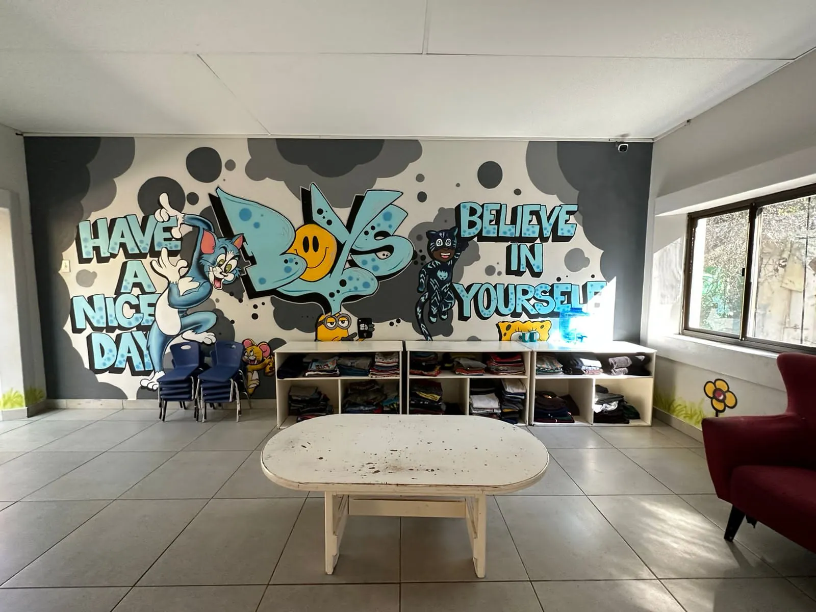 A playroom at Lorato House with a bright mural reading Believe in Yourself