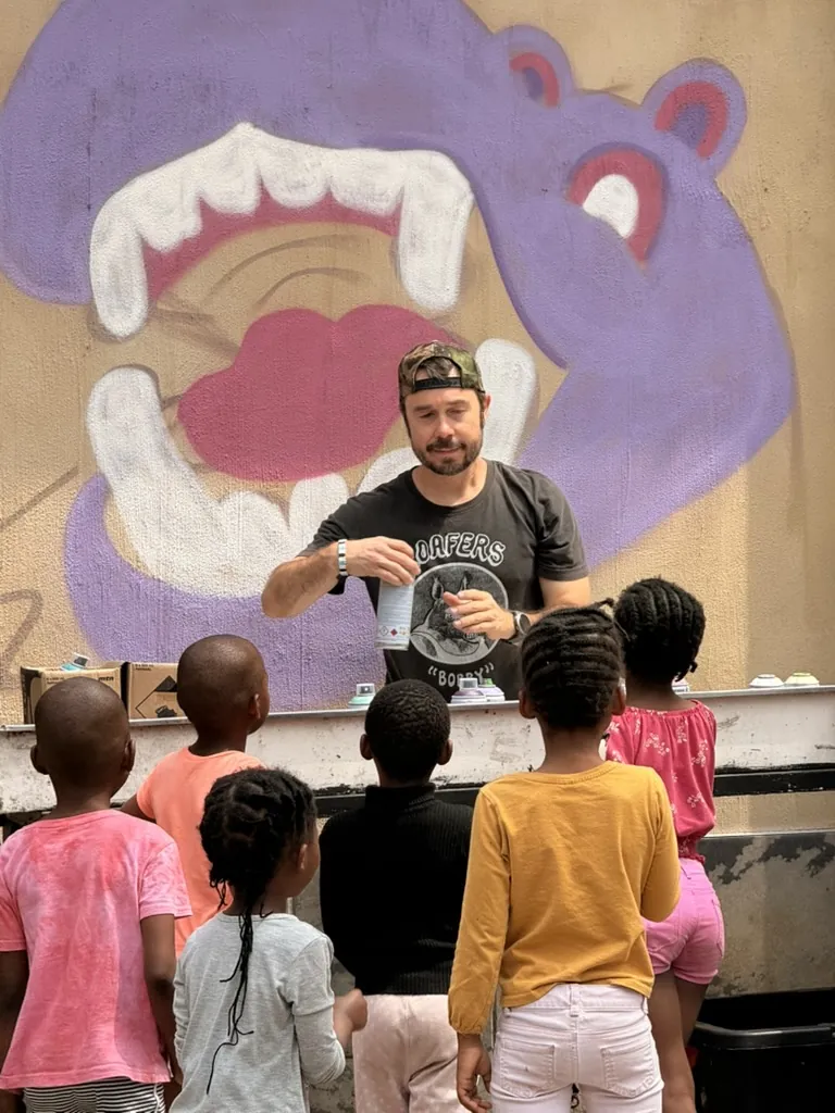 Children seen from behind at an activity in front of a hippo mural