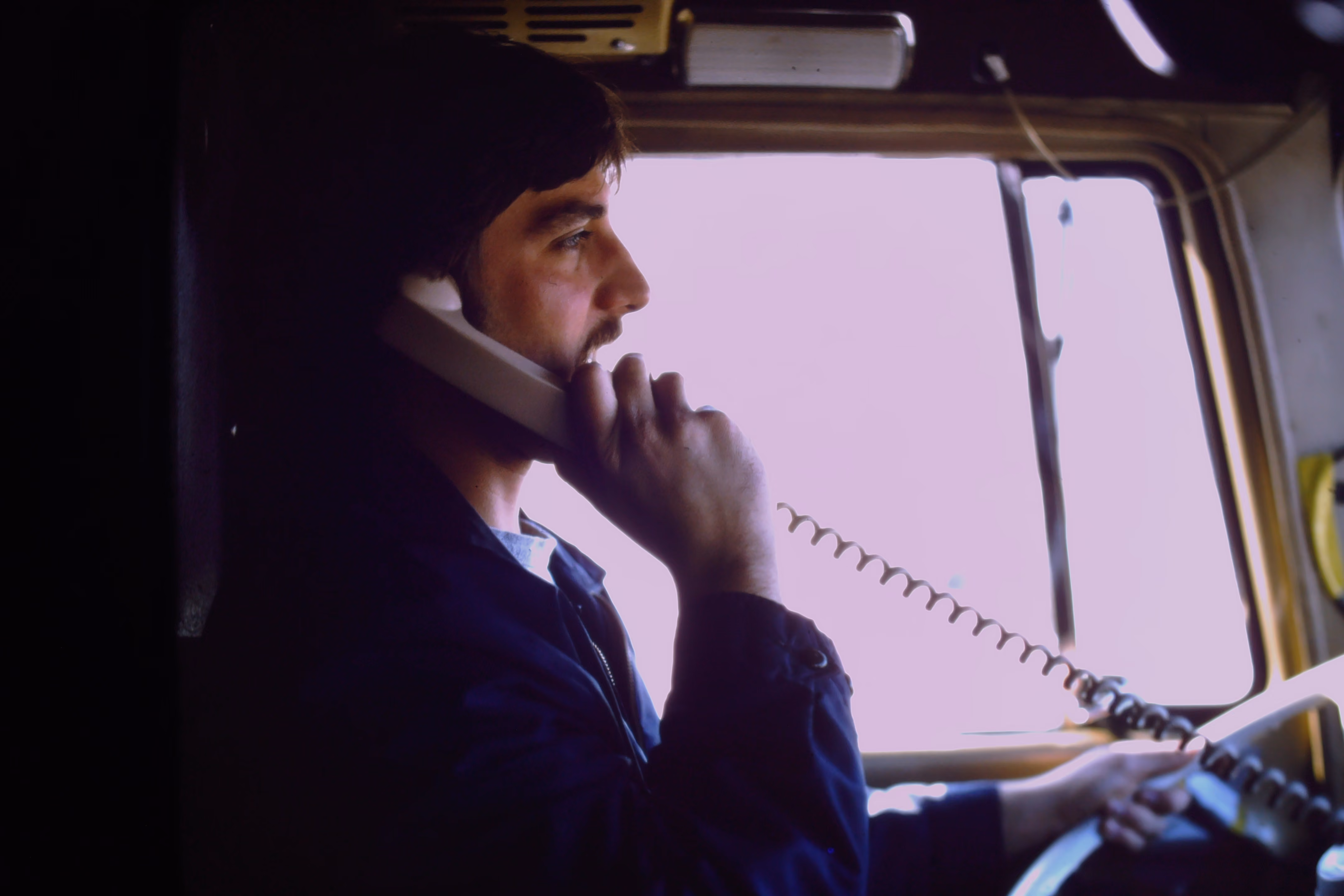Jim Ober driving a truck while using a corded phone