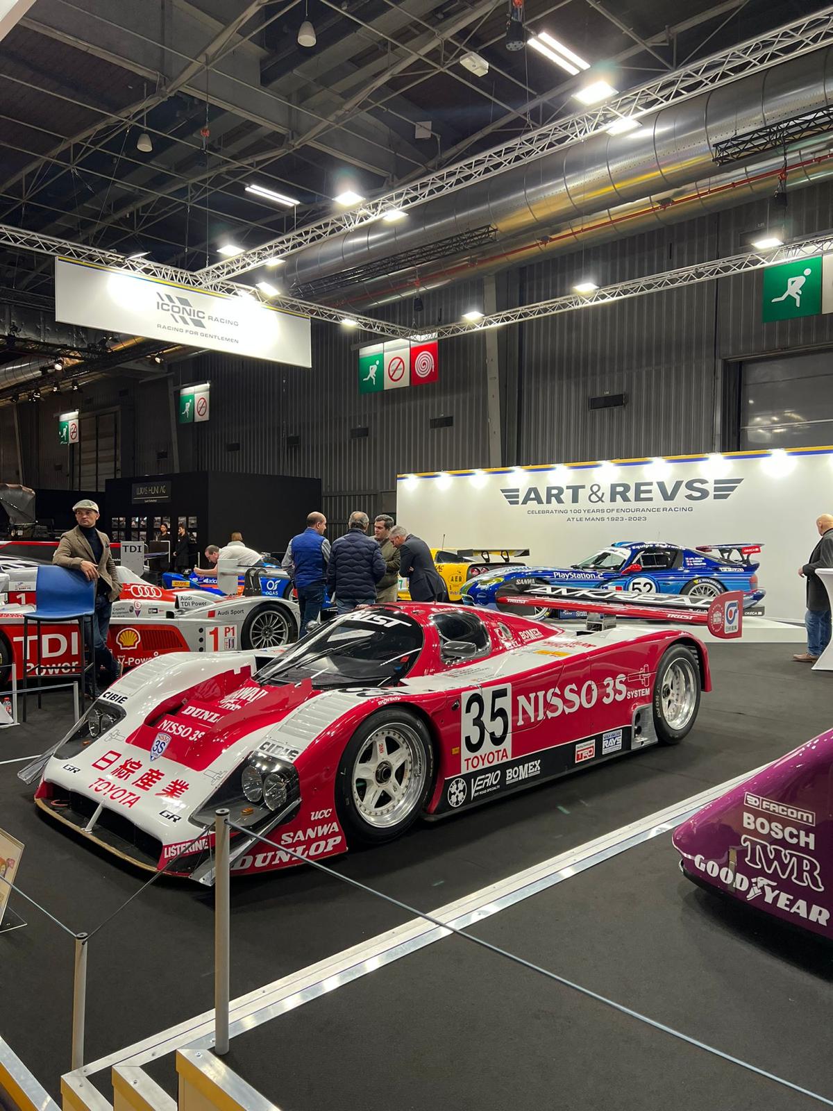 Stand d'exposition au salon Rétromobile, voitures de collection présentées dans un hall du parc des expositions.