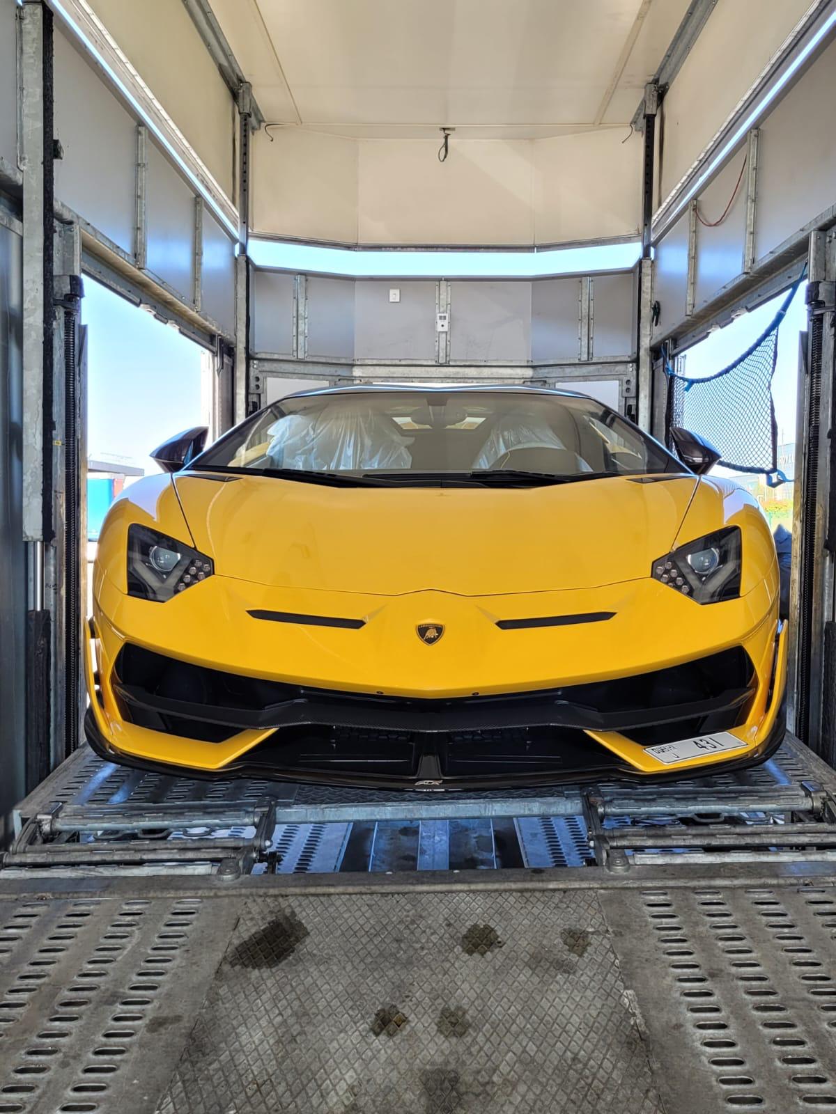 Lamborghini sanglée à l'intérieur d'un camion fermé Carshipment, prête pour un transport routier longue distance.