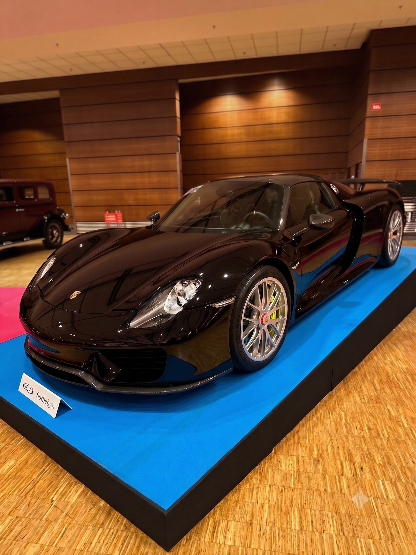 Porsche 918 présentée sur podium lors d'une vente aux enchères RM Sotheby's