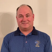 Smiling man wearing a blue patterned polo shirt with an IBEW logo on the chest.