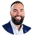 Smiling man with a beard wearing a blue suit and white shirt, against a white background.