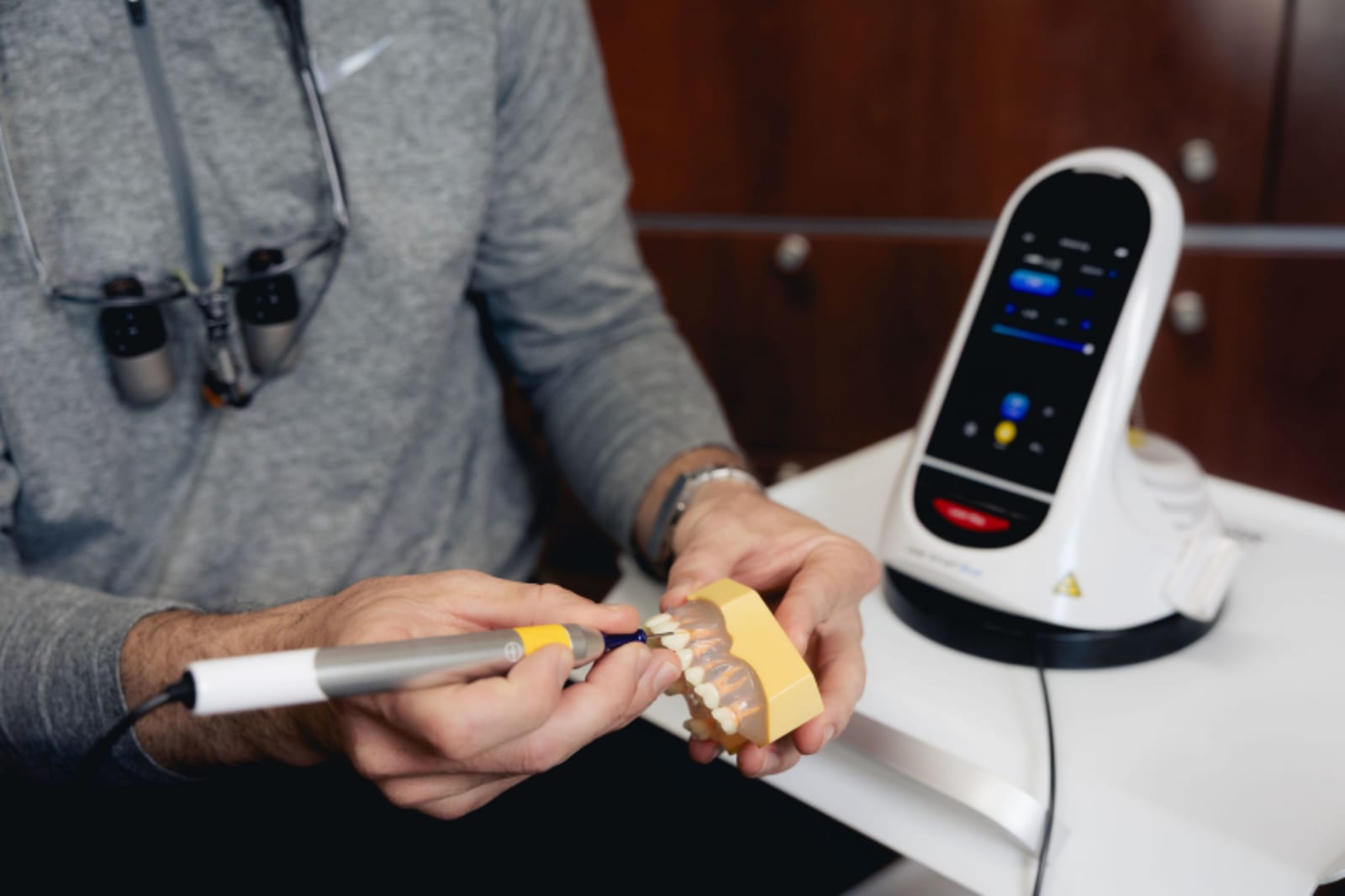Dentist examining dental model with digital scanner during treatment planning