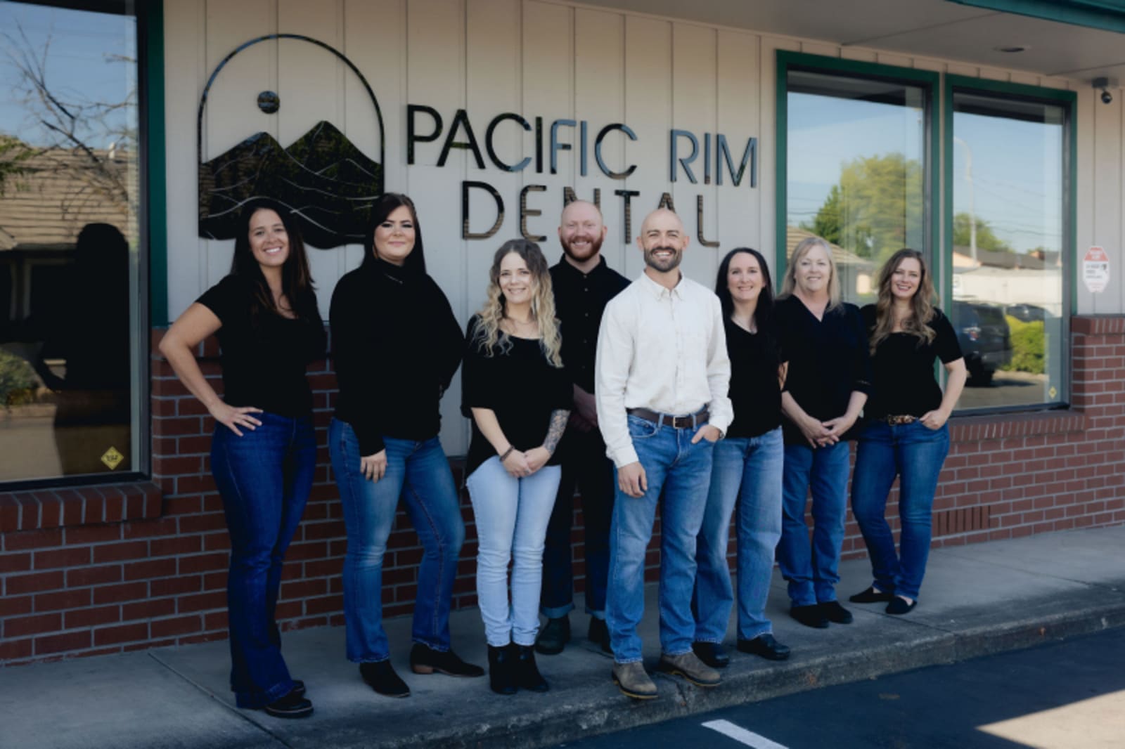 Pacific Rim Dental team standing together in front of practice entrance