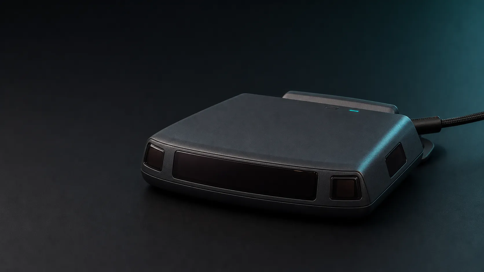 Matte-graphite BanditKin Sentinel roadside-awareness receiver with a wide dark front sensor panel, four small optical receiver windows, windshield cradle, and USB-C cable. Product render.