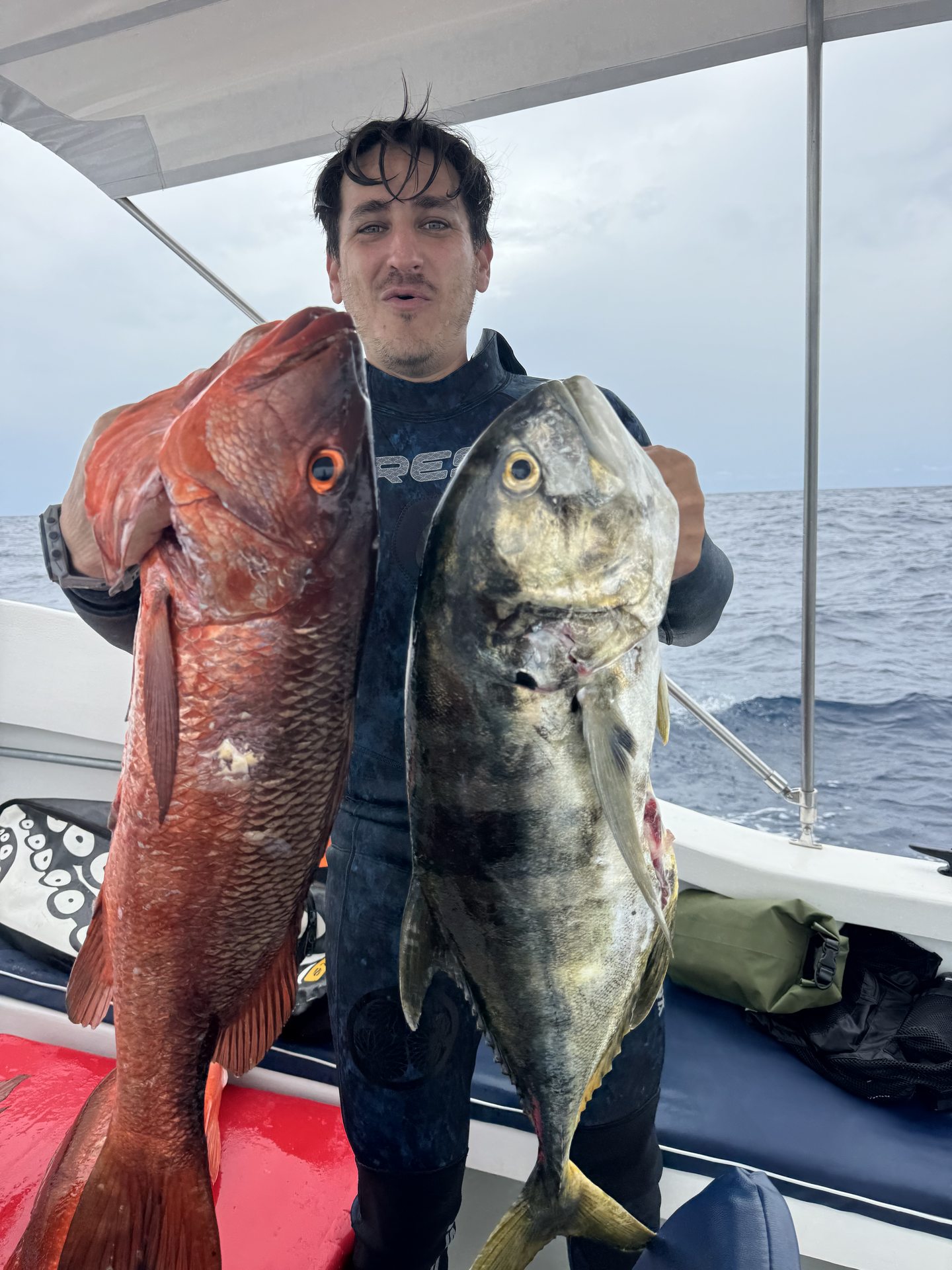 A guest displaying catches under the boat canopy