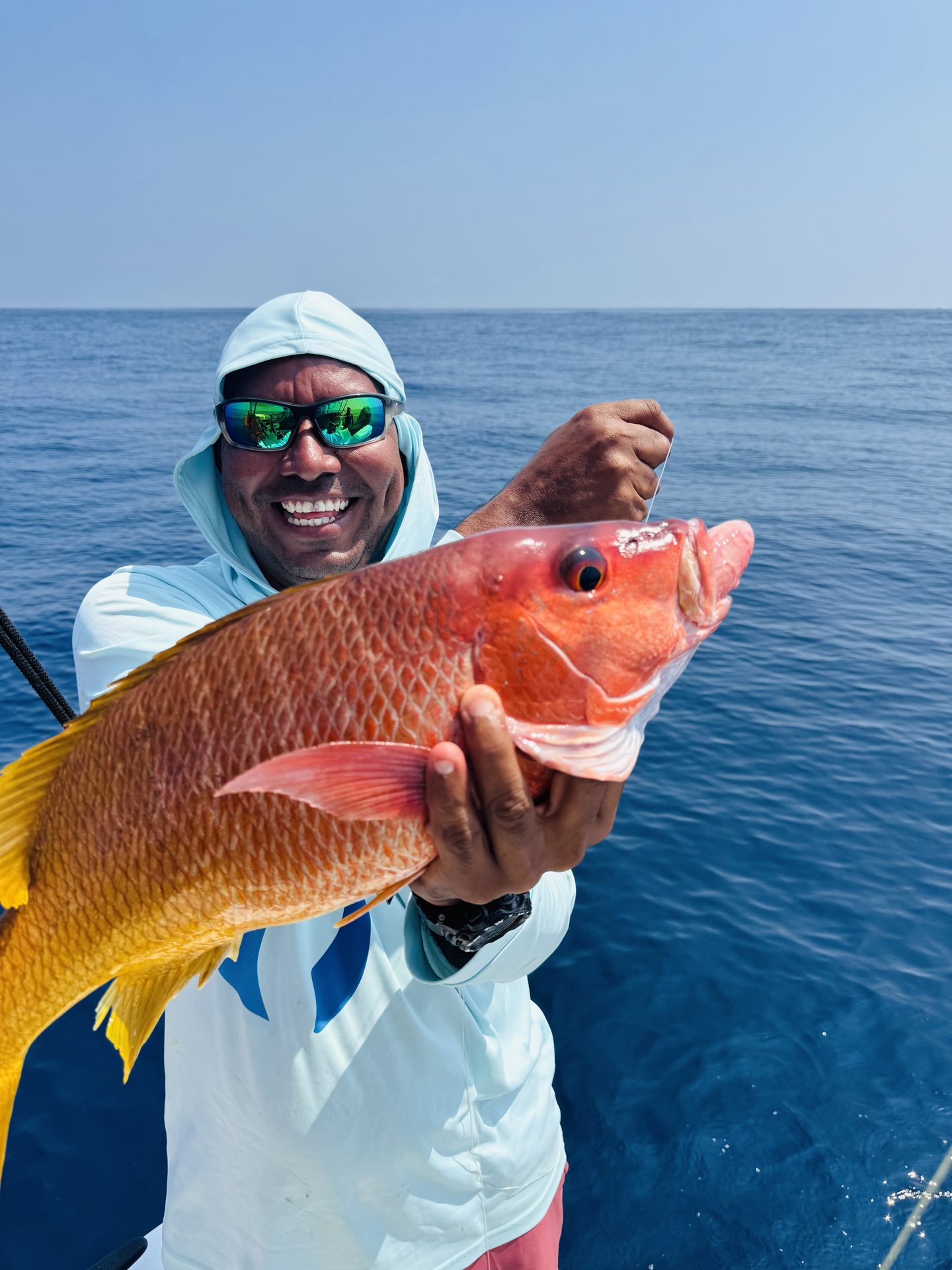 A guest holding a snapper on the Pacific
