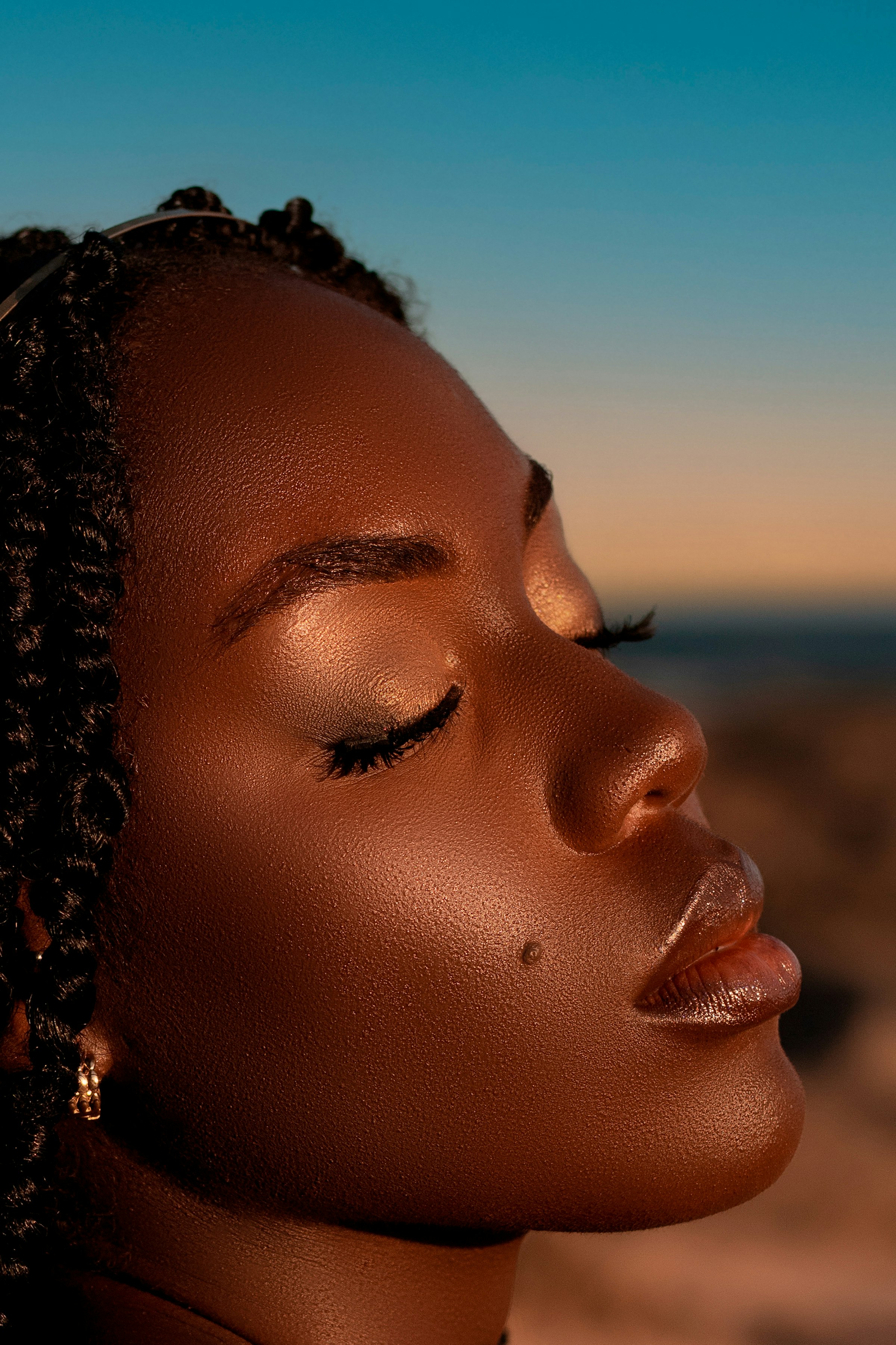 Close-up profile of a woman with luminous skin and eyes closed