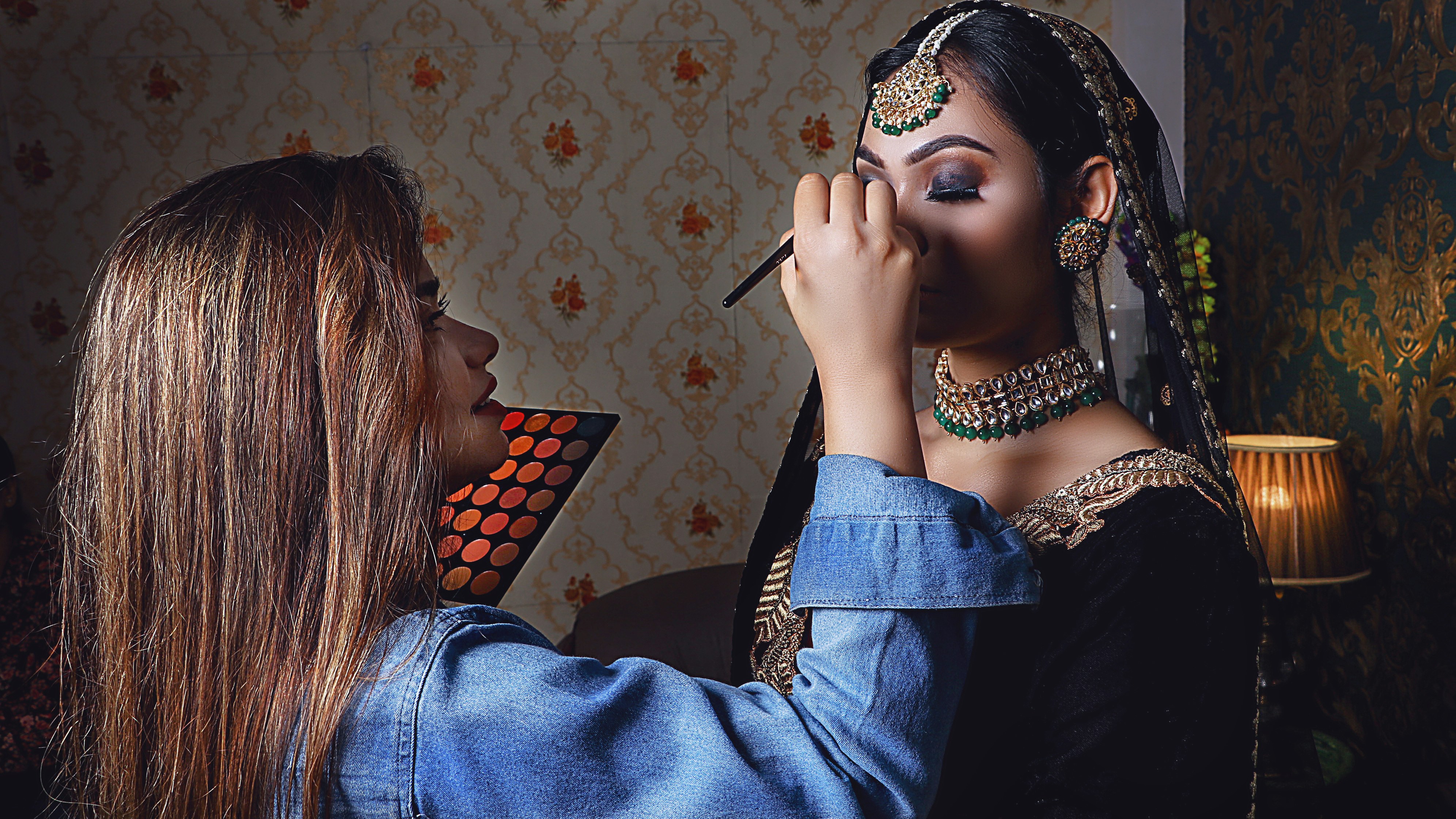 A makeup artist applying makeup to a client's face with a brush