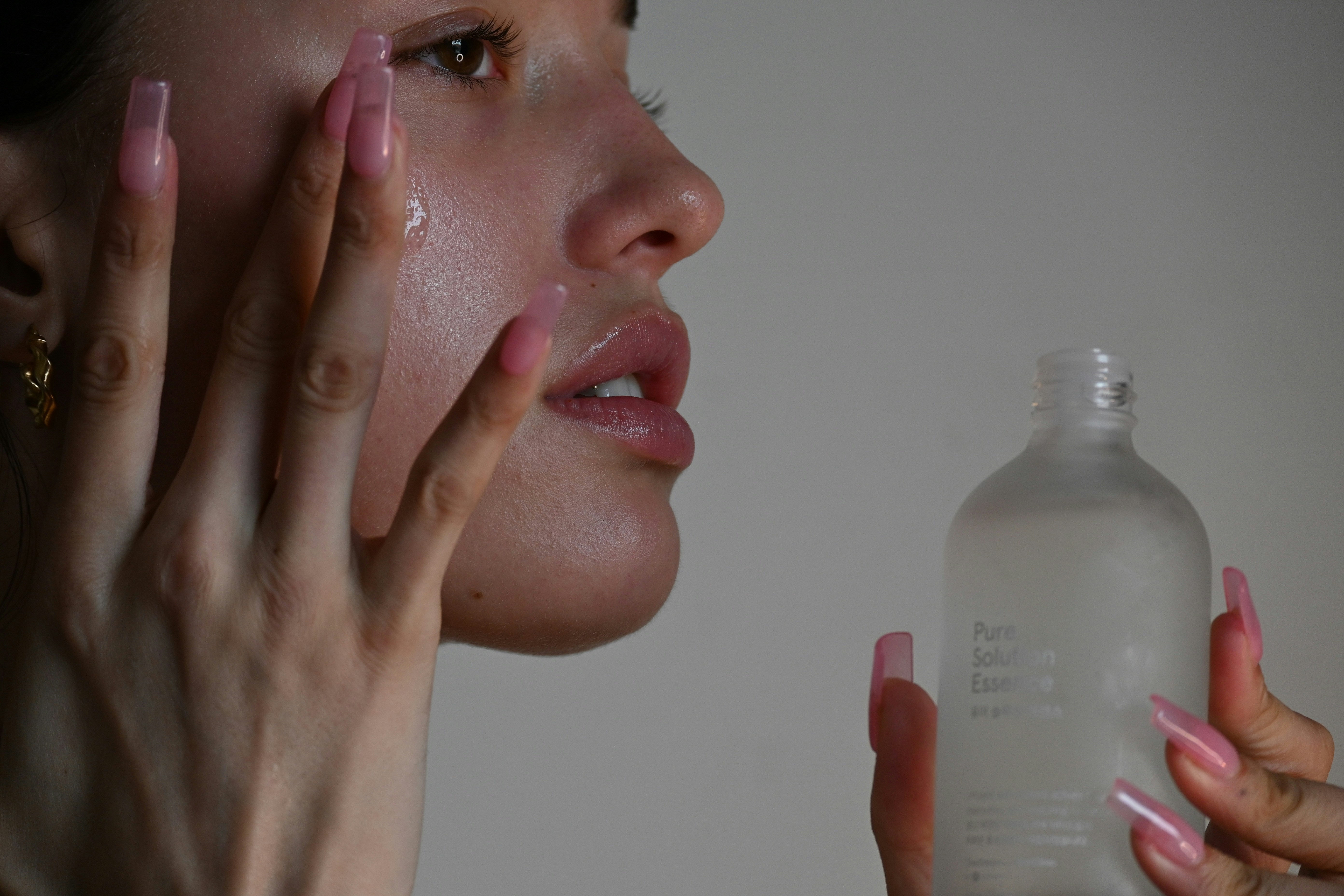 A woman pressing serum into her cheek