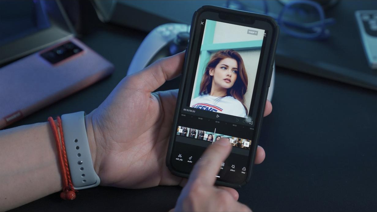 A person editing a video on a phone, timeline visible on screen