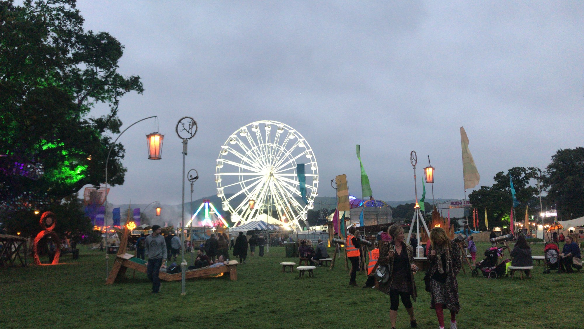 Lanterns and flags in front of the big wheel at Electric Picnic at dusk.