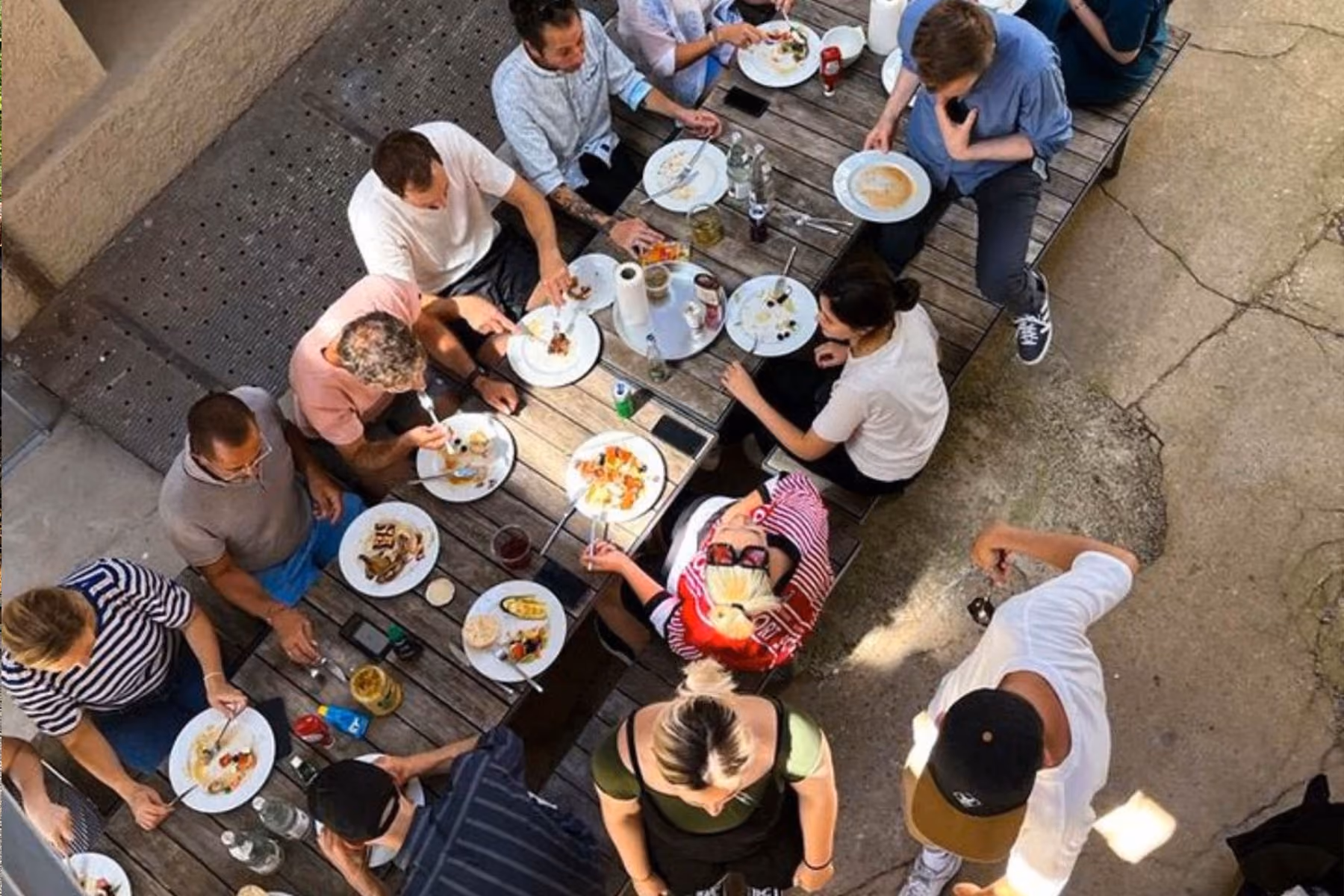 Vogelperspektive auf das Designplus-Team beim gemeinsamen Mittagessen im Freien