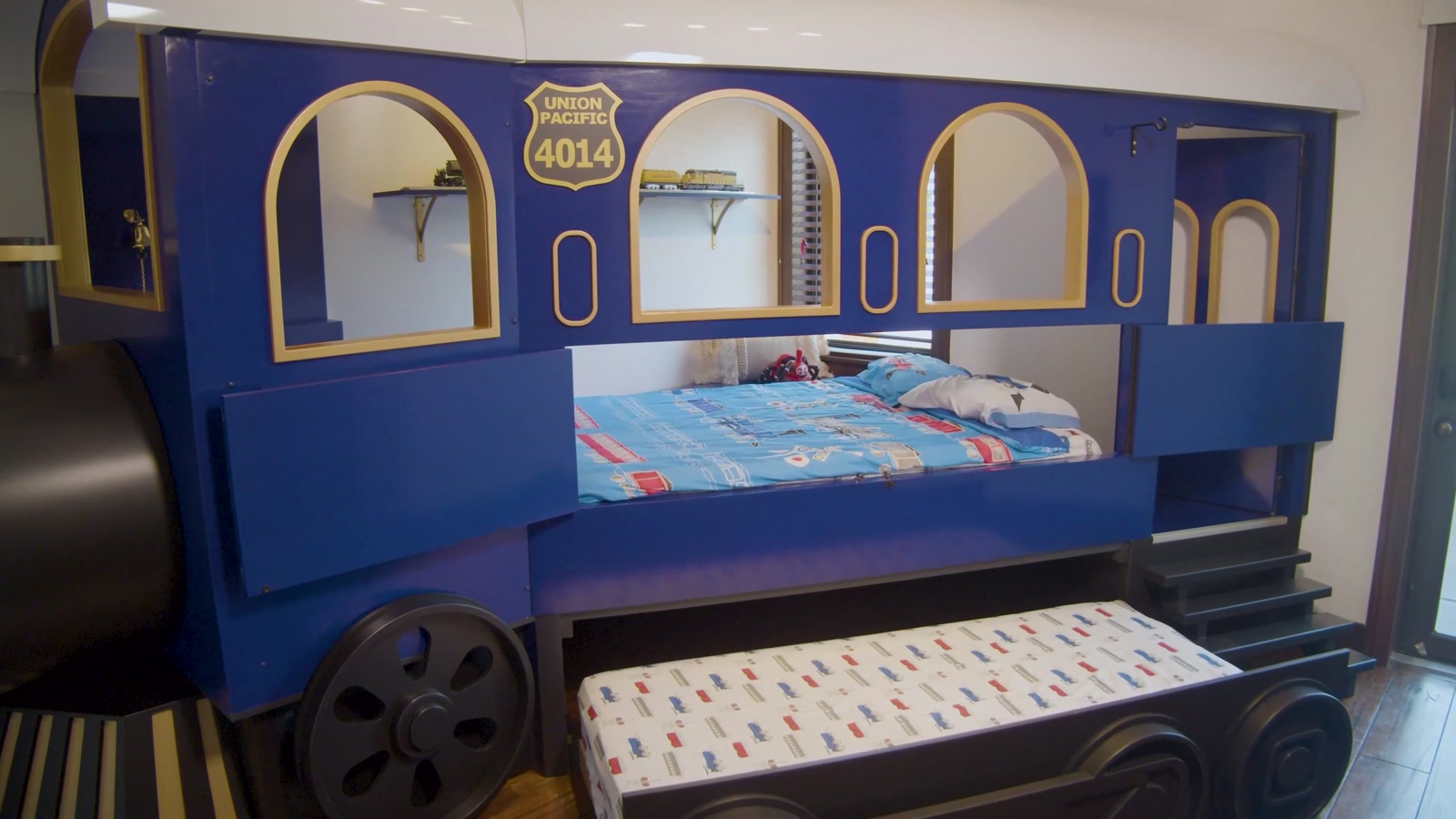 Completed blue and gold train bed with its trundle extended