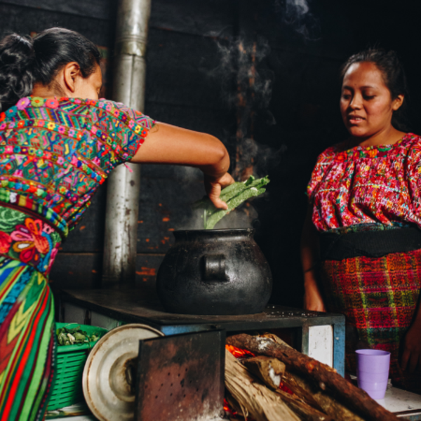 Two women in Guatemala boiling swiss chard wraps to make boxboles