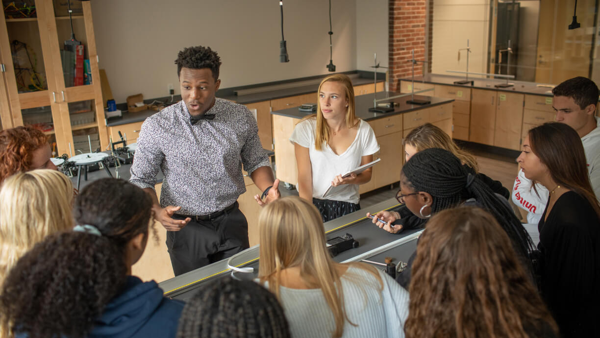 Students at Blair Academy (NJ) gathered around a table listening to their teacher.
