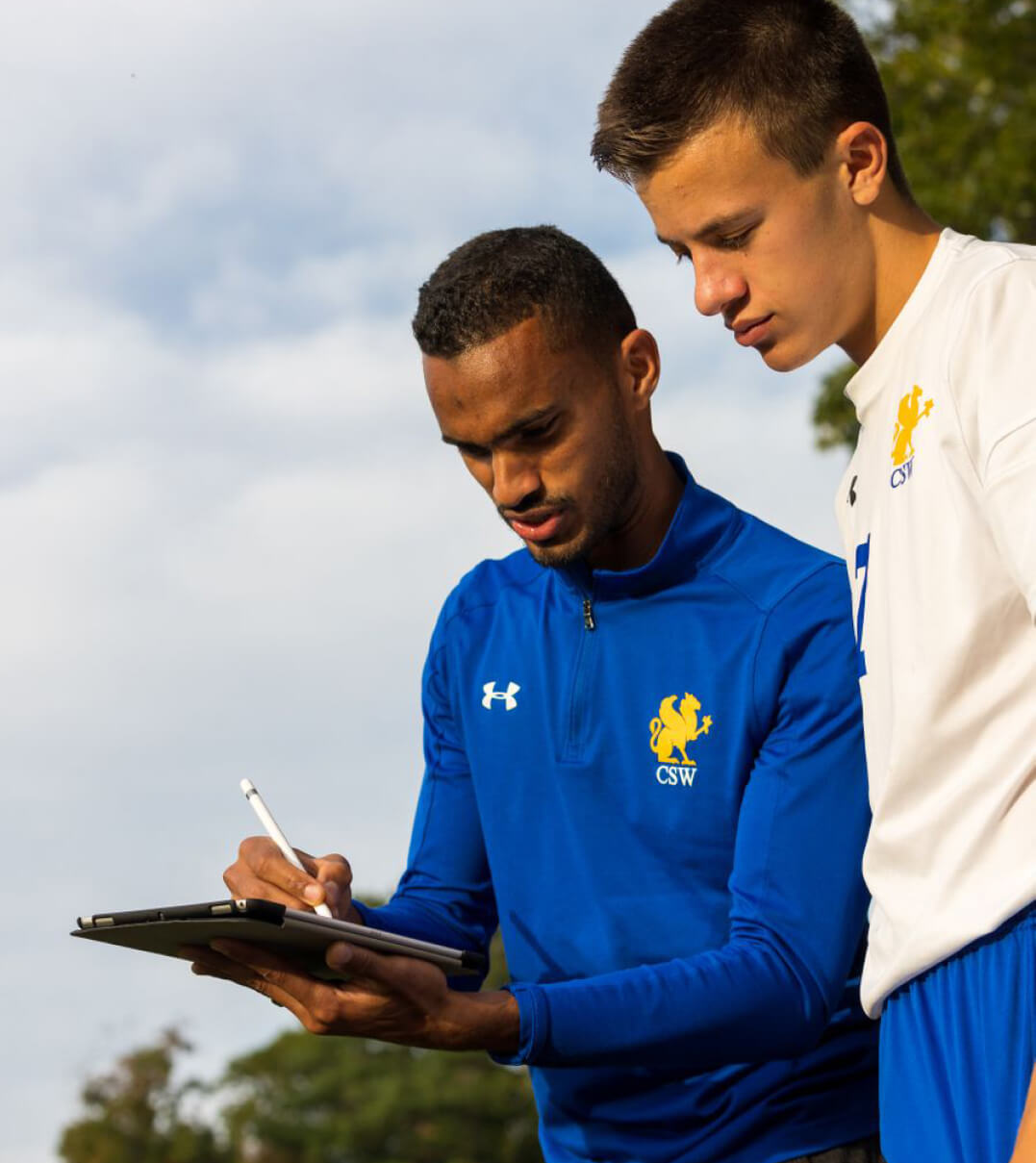 A CSW soccer coach giving a player instructions.