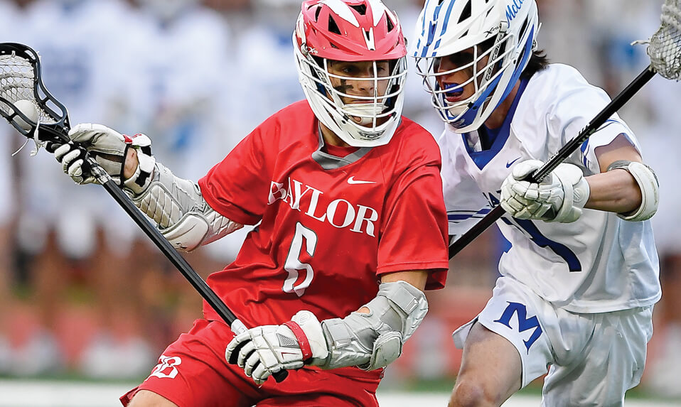 A Baylor School lacrosse player driving past a defender.