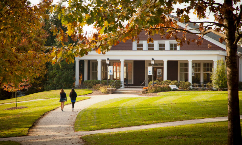 Two students walking across the Garrison Forest School campus in the fall.