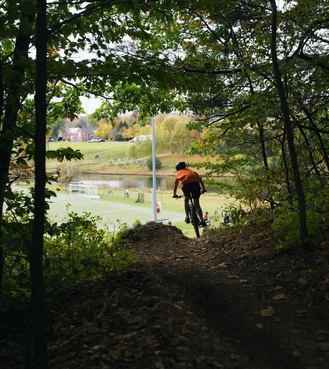 A KUA student riding down a mountain biking trail.