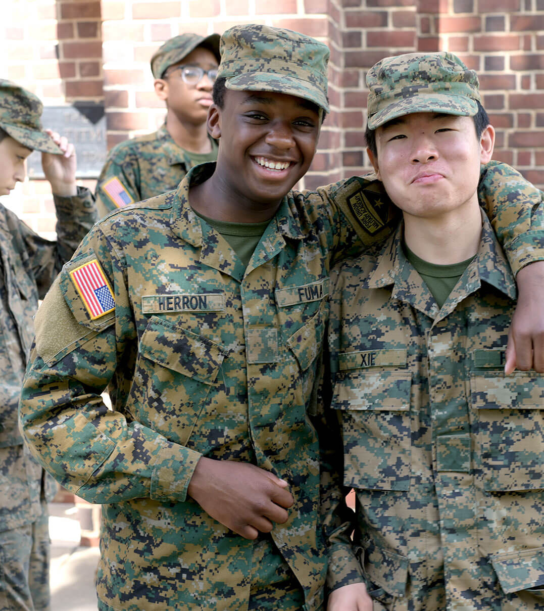 Two Fork Union cadets in their uniforms with their arms around each other's shoulders.