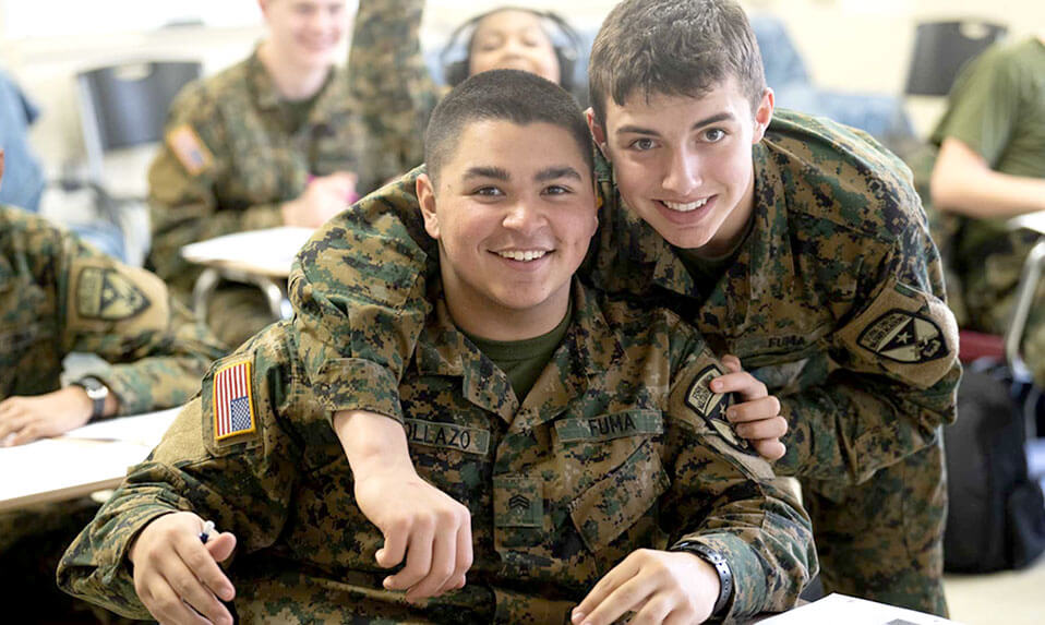 Two Fork Union cadets in the classroom smiling at the camera.