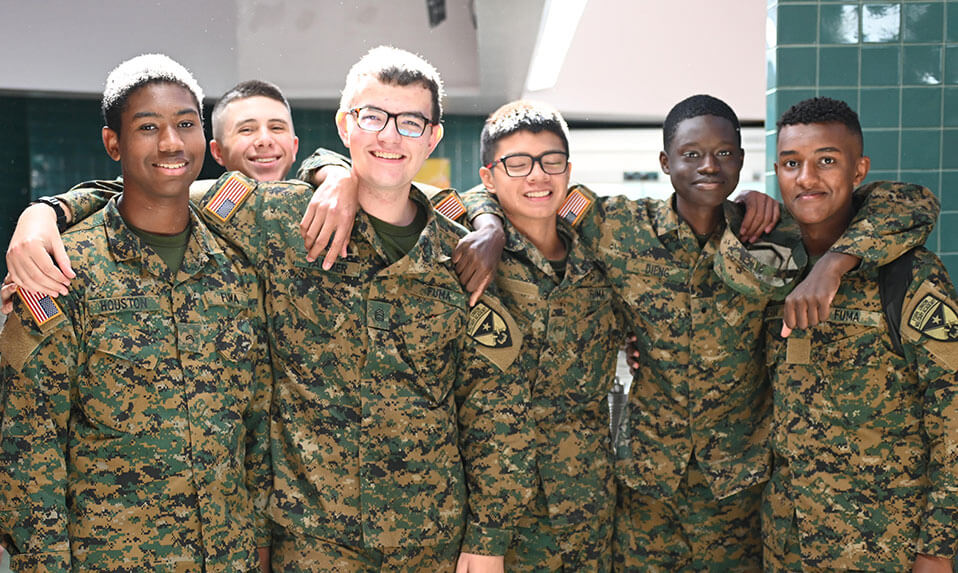 A group of Fork Union Military Academy cadets standing with the arms around each others' shoulders.