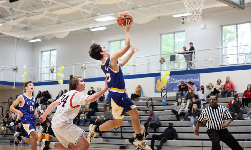 A CSW basketball player going up for a fast-break layup.