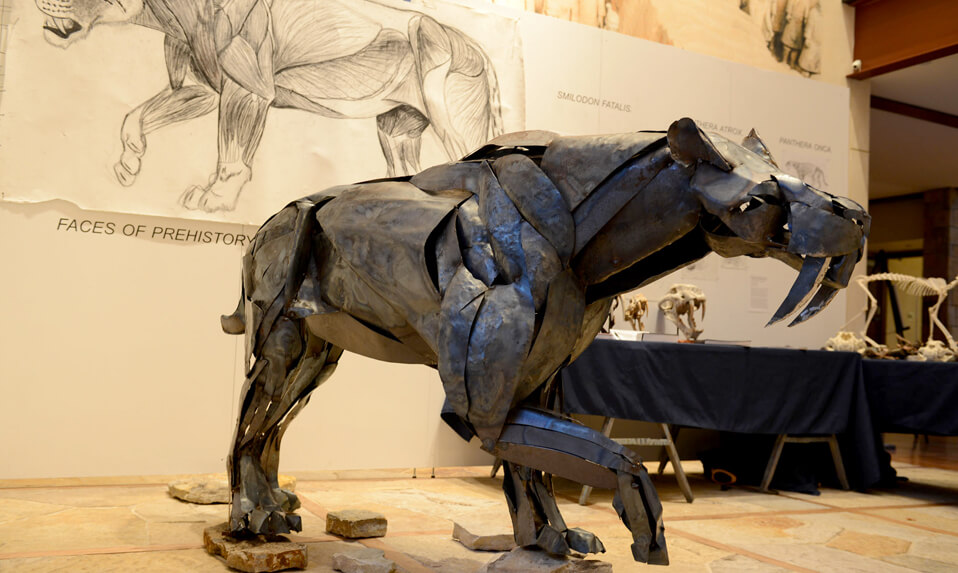 A metal sculpture of a saber-toothed tiger.