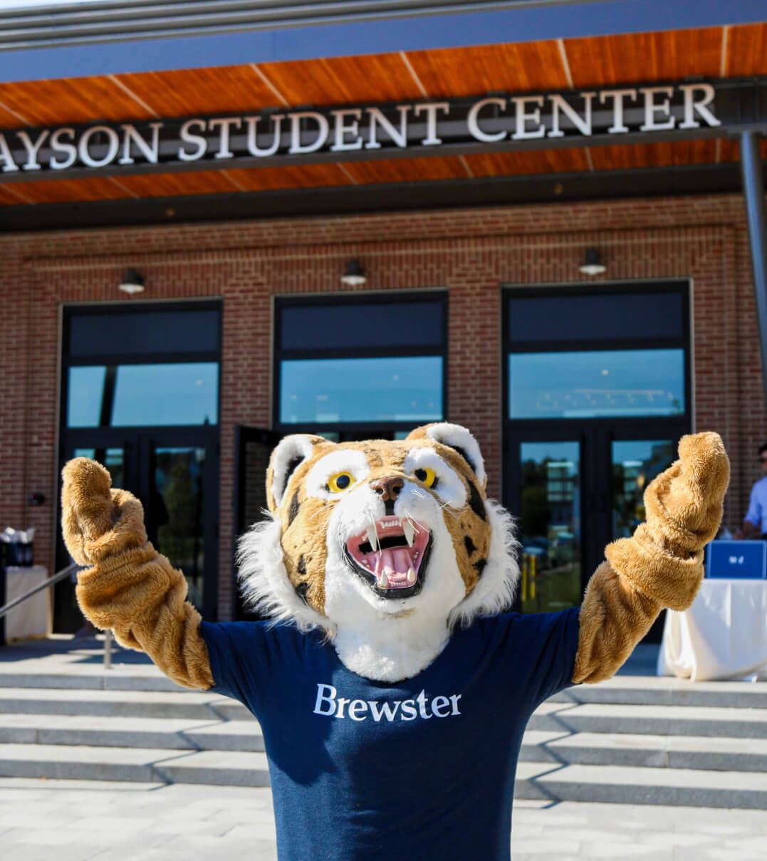 The Brewster tiger mascot raising its hands in celebration outside of the Grayson Student Center.