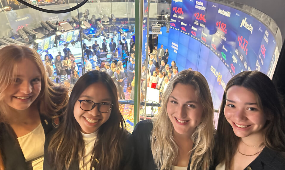 A group of WMA students posing above the Nasdaq stock exchange.