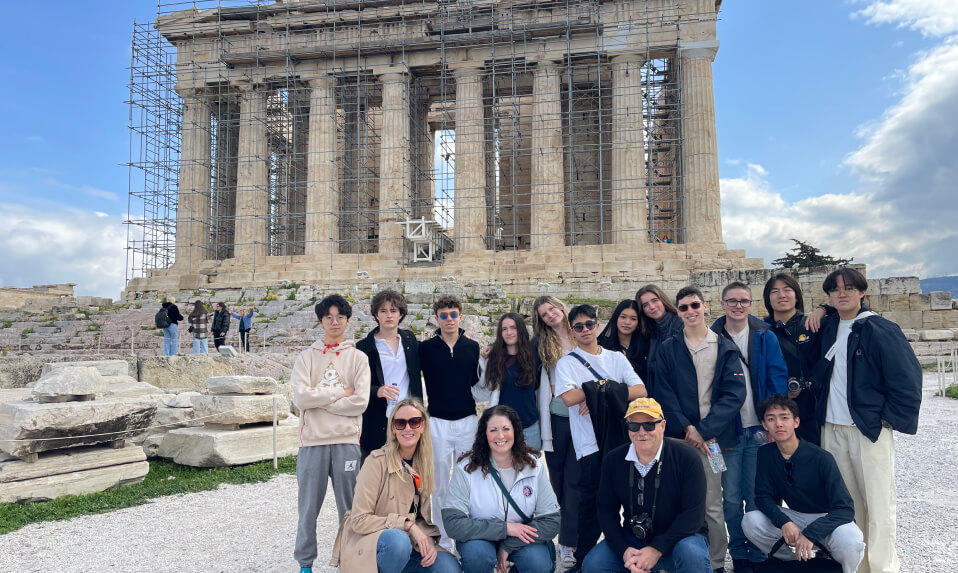 A group of WMA students and adult leaders posing for a photo in front of the Parthenon in Athens, Greece.