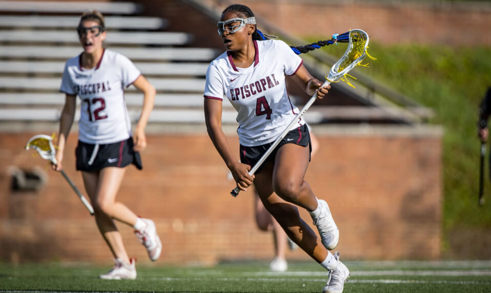 An Episcopal High School (VA) lacrosse player carries the ball downfield.